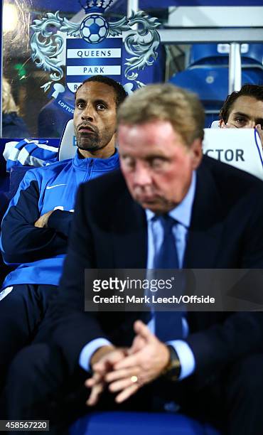 Rio Ferdinand of QPR on the bench behind Harry Redknapp, Manager of Queens Park Rangers during the Premier League match between Queens Park Rangers...