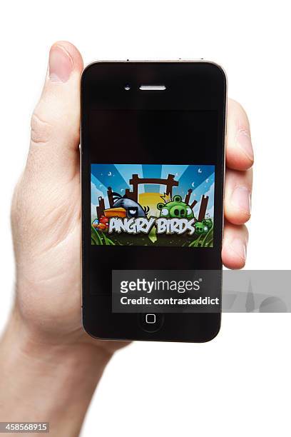 hand holding iphone 4 with angry birds on the screen. - angry birds namngivna videospel bildbanksfoton och bilder