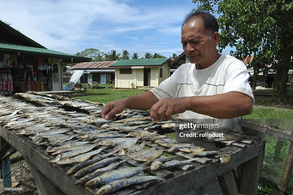 Homem tenting peixe seco.