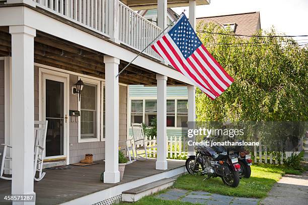 motorcycles parked under usa flag - small town america stock pictures, royalty-free photos & images