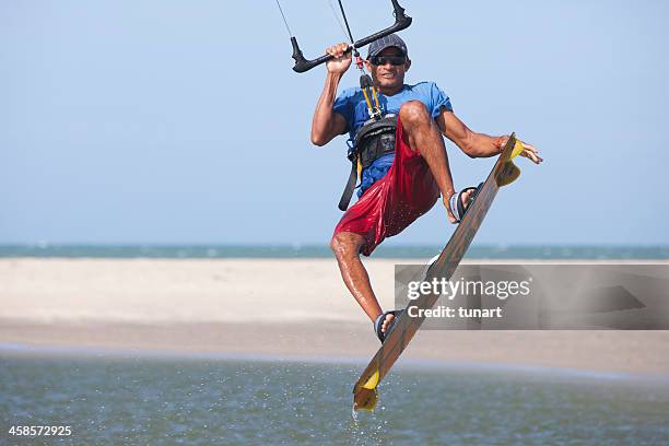 young man kite surfing in a lagoon of jericoacoara, brazil - kite lagoon stock pictures, royalty-free photos & images