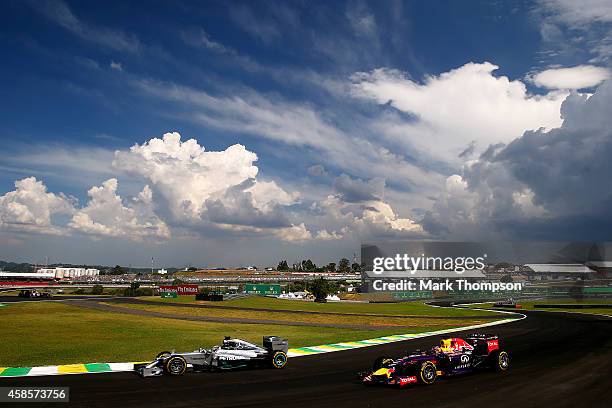 Sebastian Vettel of Germany and Infiniti Red Bull Racing and Lewis Hamilton of Great Britain and Mercedes GP drive during practice ahead of the...