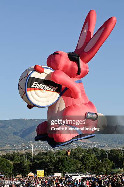 energizer bunny hot air balloon rising over crowd at sunrise - energizer bunny stock pictures, royalty-free photos & images