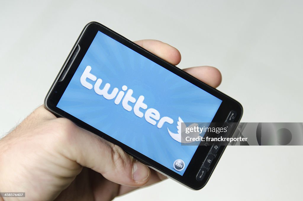Mão a segurar num smarthphone Mostrar twitter aplicação