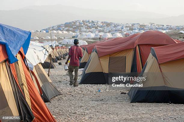 homme marchant entre tentes - haïti photos et images de collection