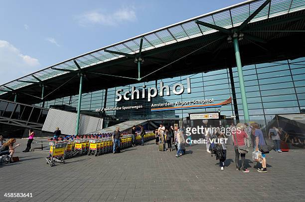 travellers at the entrance of amsterdam airport schiphol - schiphol airport stockfoto's en -beelden