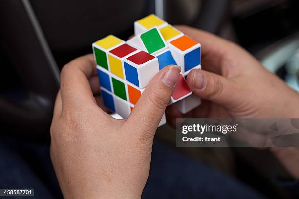 hands playing a cube game - solving rubix cube stock pictures, royalty-free photos & images