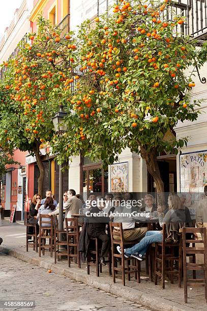 gente sentada en un café en sevilla - andalusia fotografías e imágenes de stock