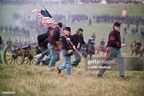 civil war reenactment soldiers running with artillery piece - civil war stock pictures, royalty-free photos & images