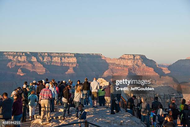 crowds of tourists watch the sunset from mather point - mather point stock pictures, royalty-free photos & images