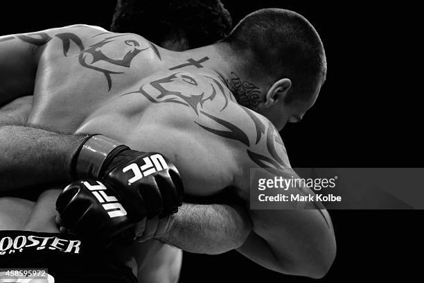The tattoos of Guto Inocente are is seen in the Octagon as he fights Anthony Perosh in their light heavyweight fight during the UFC Fight Night 55...
