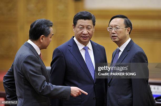 China's President Xi Jinping speaks with Chinese Foreign Minister Wang Yi and Chinese State Councilor Yang Jiechi before a bilaterial meeting with...