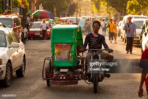 man rides a motorcycle and sidecar, manila, philippines - philippines tricycle stock pictures, royalty-free photos & images