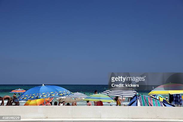 row of parasols and tourists on can picafort beach - skimpy bathing suits stock pictures, royalty-free photos & images