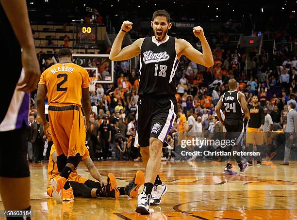 Omri Casspi of the Sacramento Kings celebrates alongside Eric Bledsoe and Marcus Morris of the Phoenix Suns after the Kings defeated the Suns 114-112...