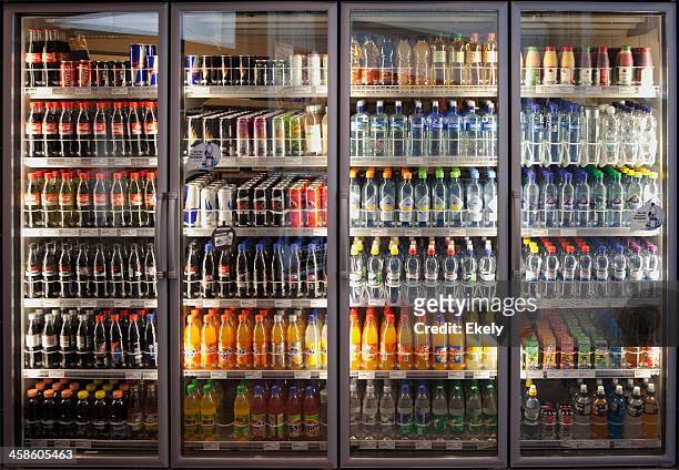 glass cabinets with diverse range of softdrinks. - cola stockfoto's en -beelden