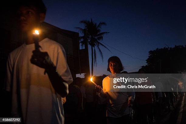 Residents of San Joaquin walk through the towns streets during a dawn candle light procession on November 8, 2014 in Tacloban, Leyte, Philippines....