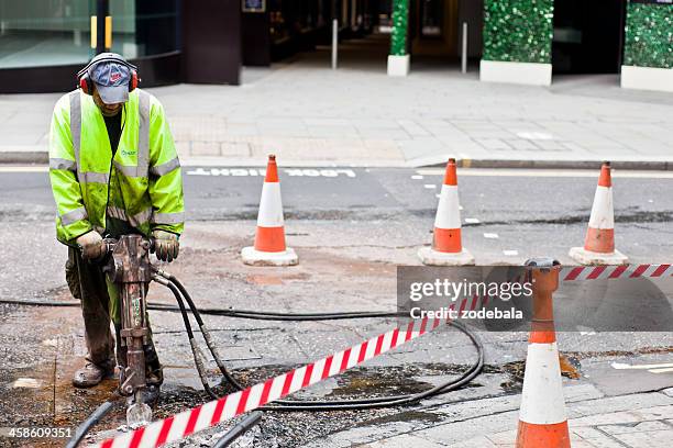 street repair worker with jackhammer in london - jackhammer stock pictures, royalty-free photos & images