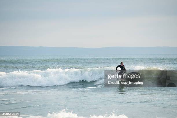man surfing at croyde bay in devon - croyde stock pictures, royalty-free photos & images