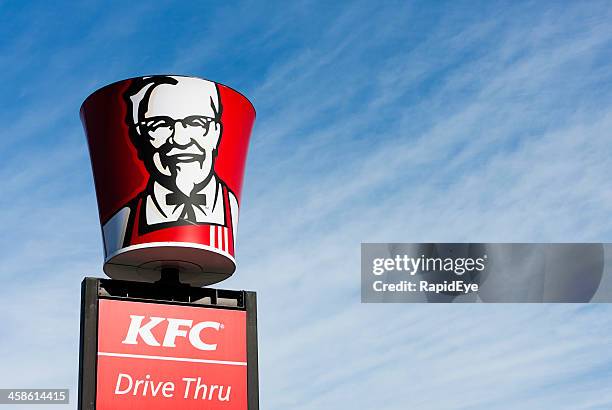 colonel sanders' image on bucket-shaped sign above kfc franchise - kentucky fried chicken bucket stock pictures, royalty-free photos & images