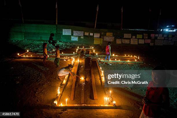 People gather on the street around candles shaped in a cross during the candlelight memorial on November 8, 2014 in Tacloban, Leyte, Philippines....