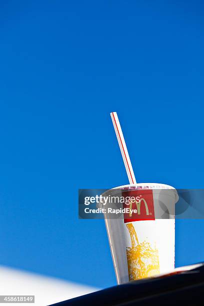 mcdonald's soft drink container on roof of car outside branch - mcdonalds restaurant stock pictures, royalty-free photos & images