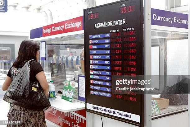 femme devant le kiosque de change pour devises étrangères - bureau de change photos et images de collection