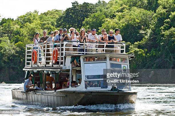 tourists on a boat; river nile, murchison falls np, uganda - uganda stock pictures, royalty-free photos & images