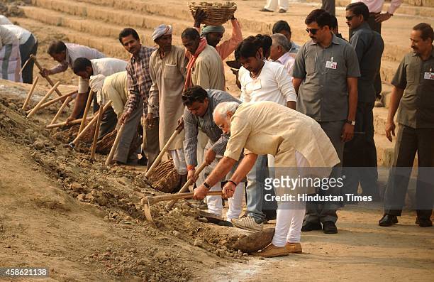 Prime Minister Narendra Modi using a shovel to clean Assi ghat on November 8, 2014 in Varanasi, India. Modi nominated nine persons, including chief...