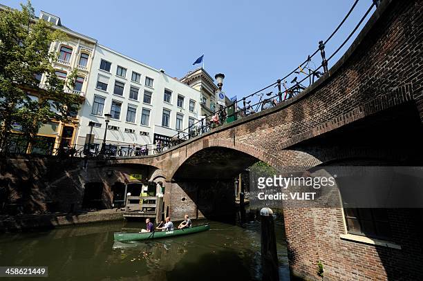 ancient arch stone bridge over the canal oudegracht in utrecht - utrecht stockfoto's en -beelden