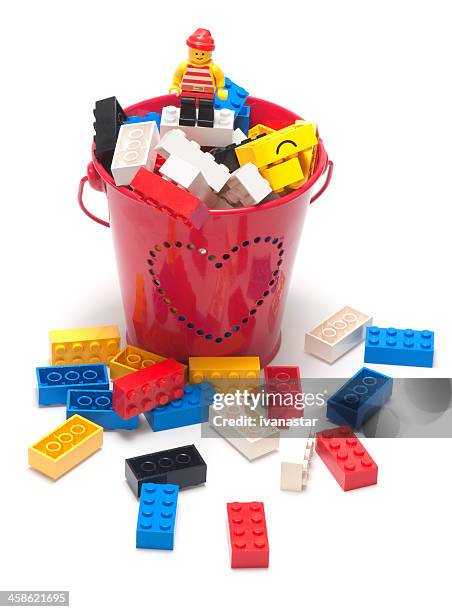 lego blocks in a bucket with pirat figurine on top - building lego stock pictures, royalty-free photos & images