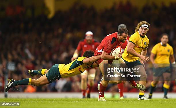 Wales player Jamie Roberts is tackled by Wallabies player Nick Phipps during the Autumn international match between Wales and Australia at Millennium...