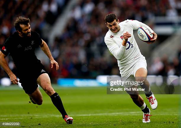 Jonny May of England breaks past Conrad Smith of New Zealand on the way to scoring the opening try during the QBE International match between England...