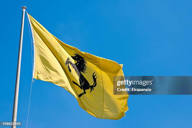 giallo ferrari bandiera soffiare nel vento contro il cielo blu - ferrari foto e immagini stock