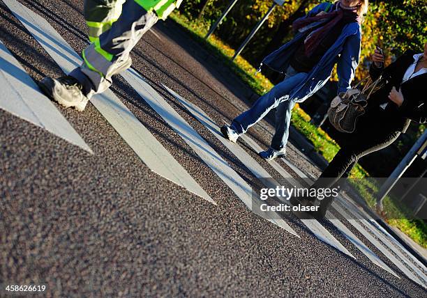 pedestrians crossing rain wet street, motion blur - solna centrum stockfoto's en -beelden