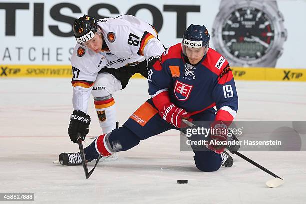 Philip Gogulla of Germany skates with Daibor Bortnak of Slovakia during match 3 of the Deutschland Cup 2014 between Germany and Slovakia at Olympia...