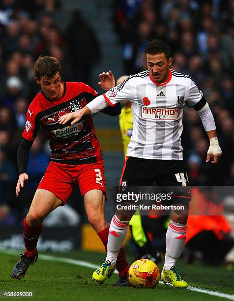 Ross McCormack of Fulham holds off the challenge of Paul Dixon of Huddersfield Town during the Sky Bet Championship match between Fulham and...