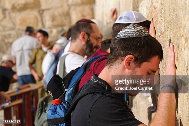 männer beten an der westlichen mauer in jerusalem - klagemauer stock-fotos und bilder