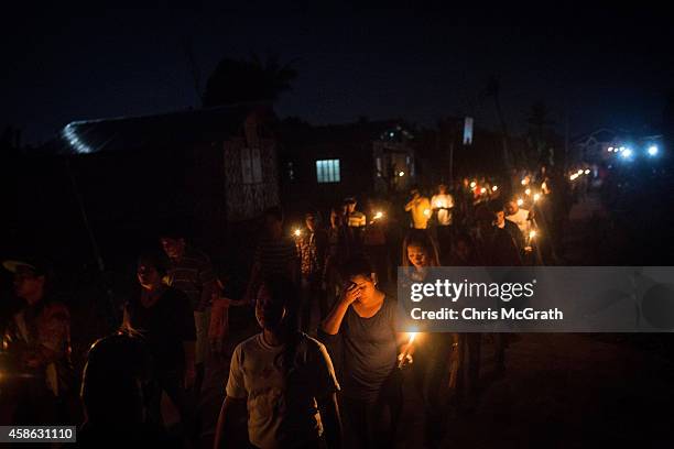 Residents of San Joaquin walk through the towns streets during a dawn candle light procession on November 8, 2014 in Tacloban, Leyte, Philippines....