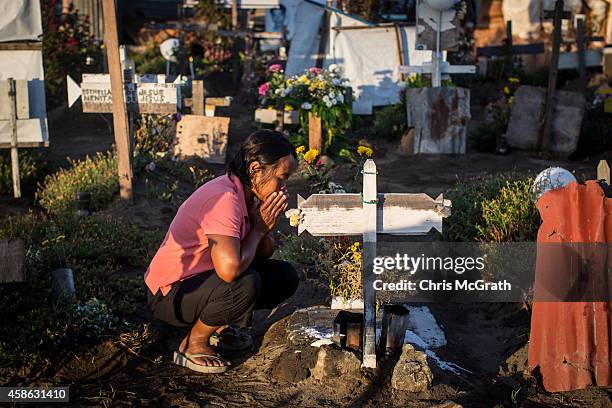 Woman sits at the grave of a loved one at the mass grave site at San Joaquin church on November 8, 2014 in Tacloban, Leyte, Philippines. Residents...