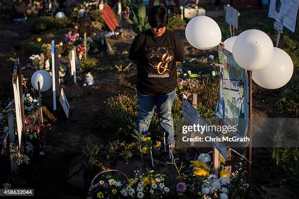 Woman stands at the grave of a loved one at the mass grave site at San Joaquin church on November 8, 2014 in Tacloban, Leyte, Philippines. Residents...