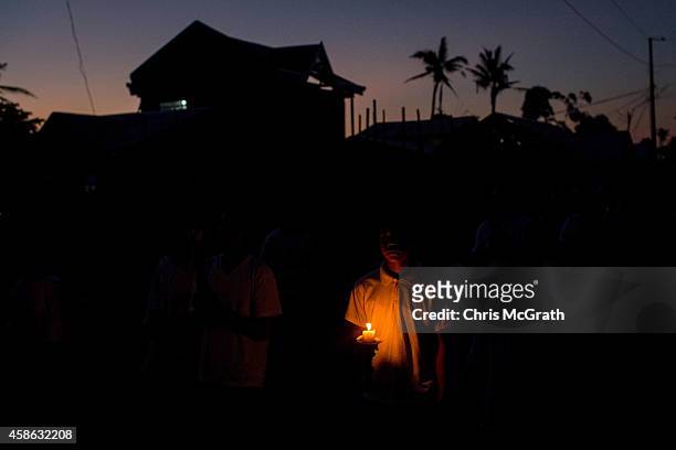 Residents of San Joaquin walk through the towns streets during a dawn candle light procession on November 8, 2014 in Tacloban, Leyte, Philippines....