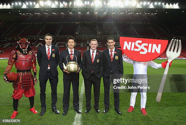 Robin van Persie, Wayne Rooney and Angel di Maria of Manchester United pose with Mr Ando, CEO of Nissin Food Holdings, ahead of a press conference to...