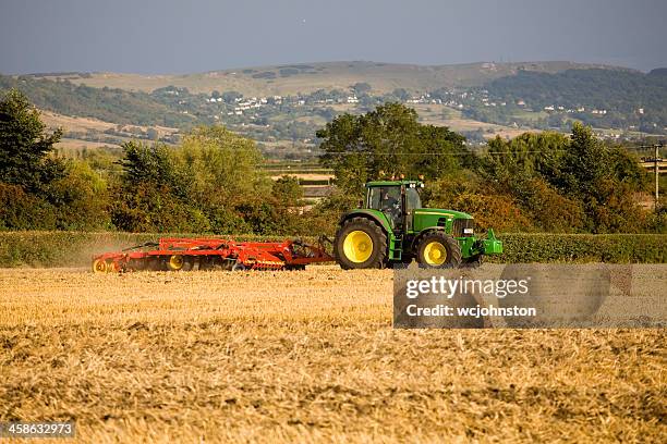 tractor ploughs a field - john deere bildbanksfoton och bilder