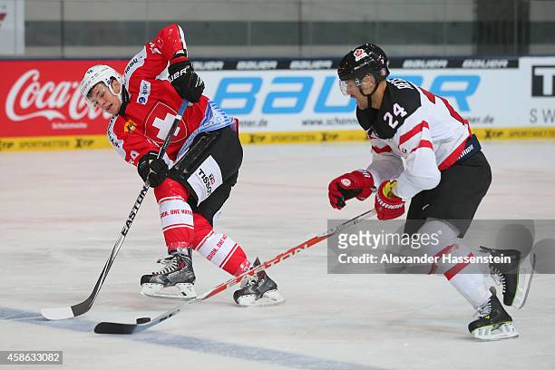 Dario Simion of Switzerland skates with Richie Regehr of Canada during match 4 of the Deutschland Cup 2014 between Switzerland and Canada at Olympia...