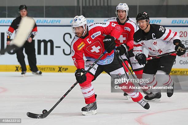 Romano Lemm of Switzerland skates with Steven Reinprecht of Canada during match 4 of the Deutschland Cup 2014 between Switzerland and Canada at...