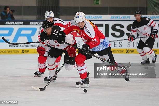 Reto Suri of Switzerland skates with Jared Aulin of Canada during match 4 of the Deutschland Cup 2014 between Switzerland and Canada at Olympia...