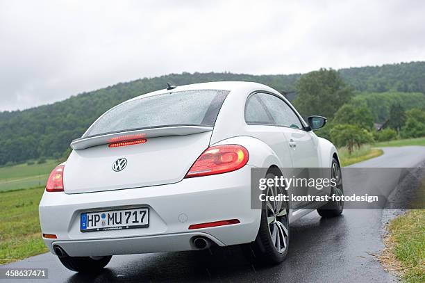 volkswagen beetle on a countryroad, bad weather conditions - new beetle stock pictures, royalty-free photos & images