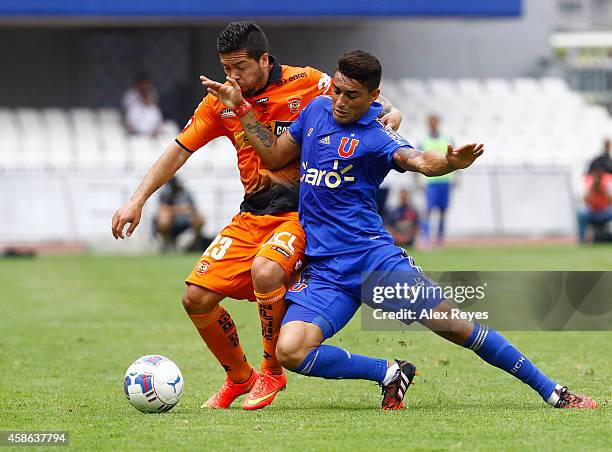 Paulo Magalhaes of U de Chile fights for the ball with Jose Luis Jimenez of Cobreloa during a match between Cobreloa and U de Chile as part of round...