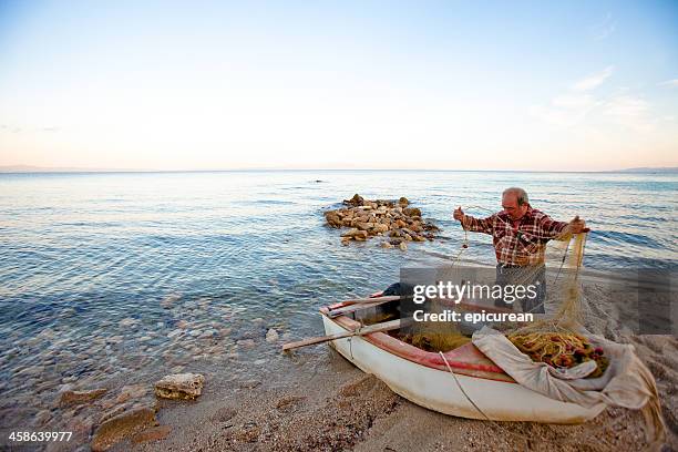 greek fisherman sorting out his fishing nets - thessaloniki greece stock pictures, royalty-free photos & images